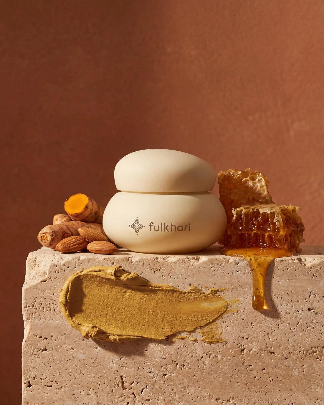 Fulkhari Golden Sunset Clay Mask jar on stone, a brightening Fuller's Earth formula with turmeric, honey, and almonds. 