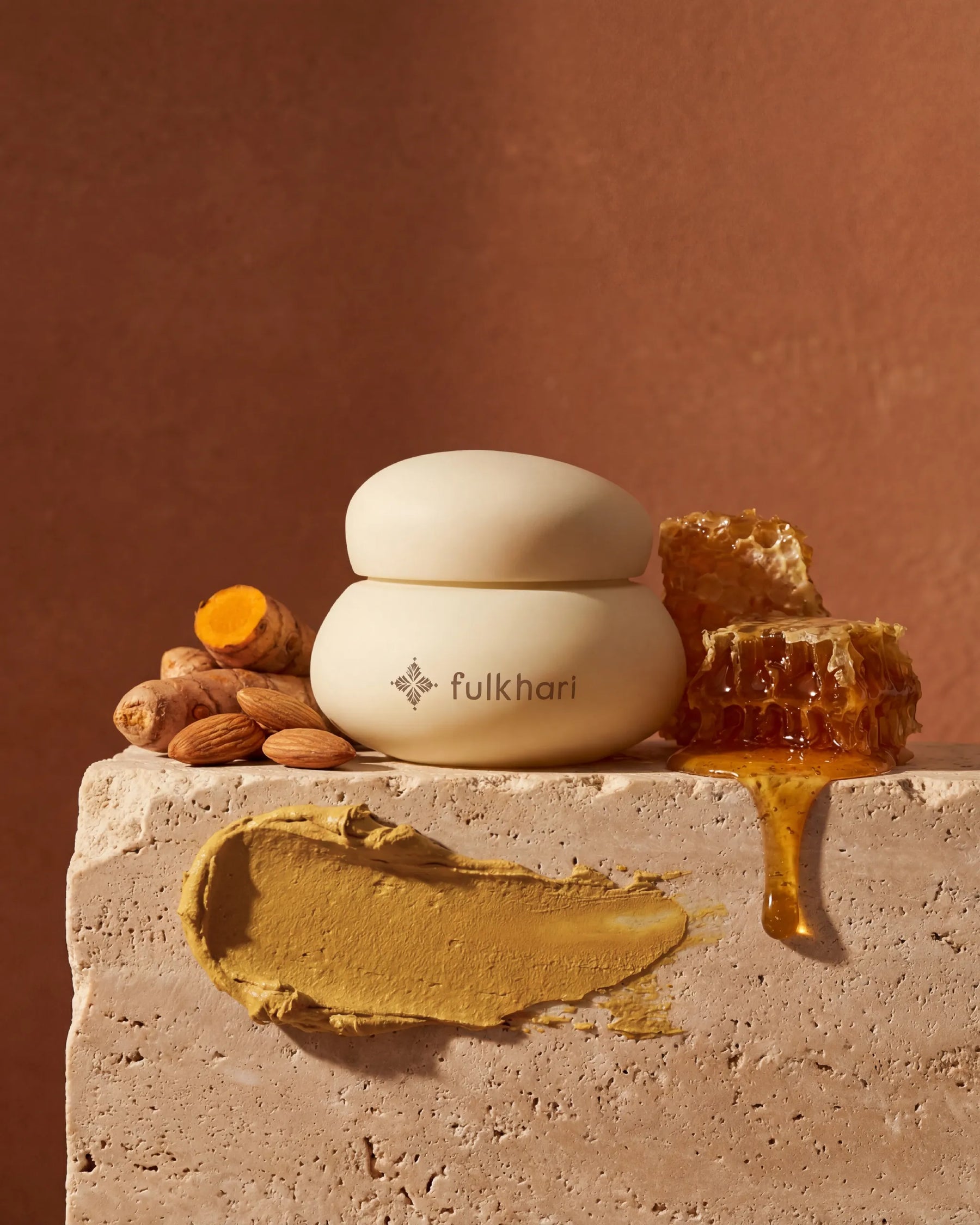 Fulkhari Golden Sunset Clay Mask jar on stone, a brightening Fuller's Earth formula with turmeric, honey, and almonds. 