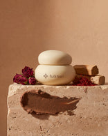 Fulkhari Rose Meadows Clay Mask jar on stone, a soothing Fuller's Earth formula with sandalwood,saffron, and rose.