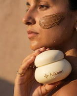 Model with bronze skin wearing the Rose Meadows Multani Mitti face pack to soothe redness and irritation.