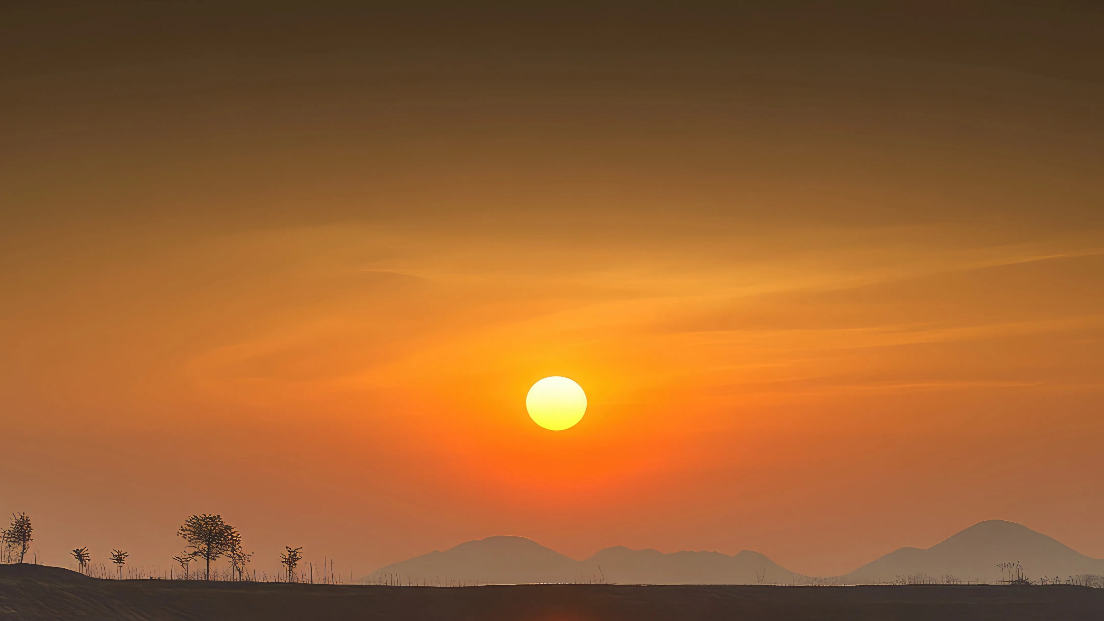 Sunset over a landscape with mountains and trees